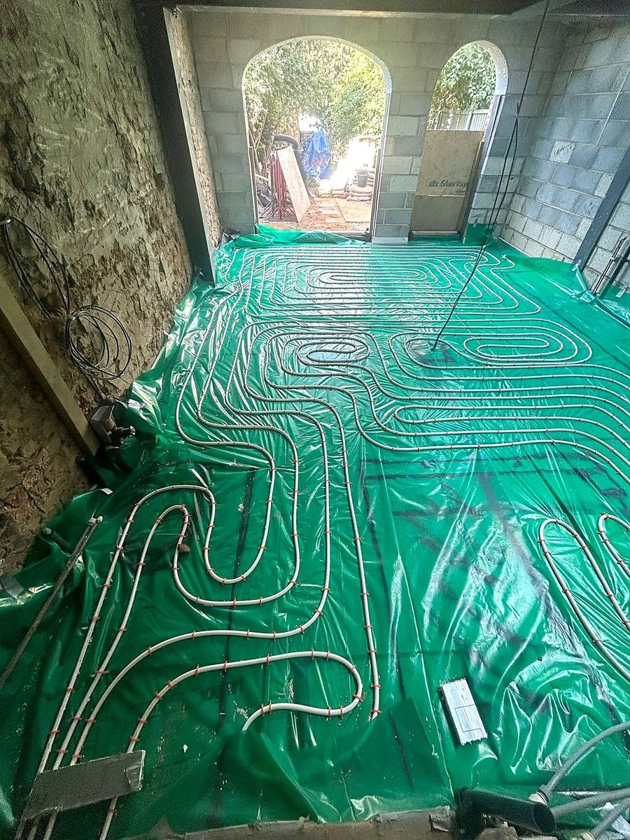 Underfloor heating circuits set out across a new ground floor extension opening onto the garden