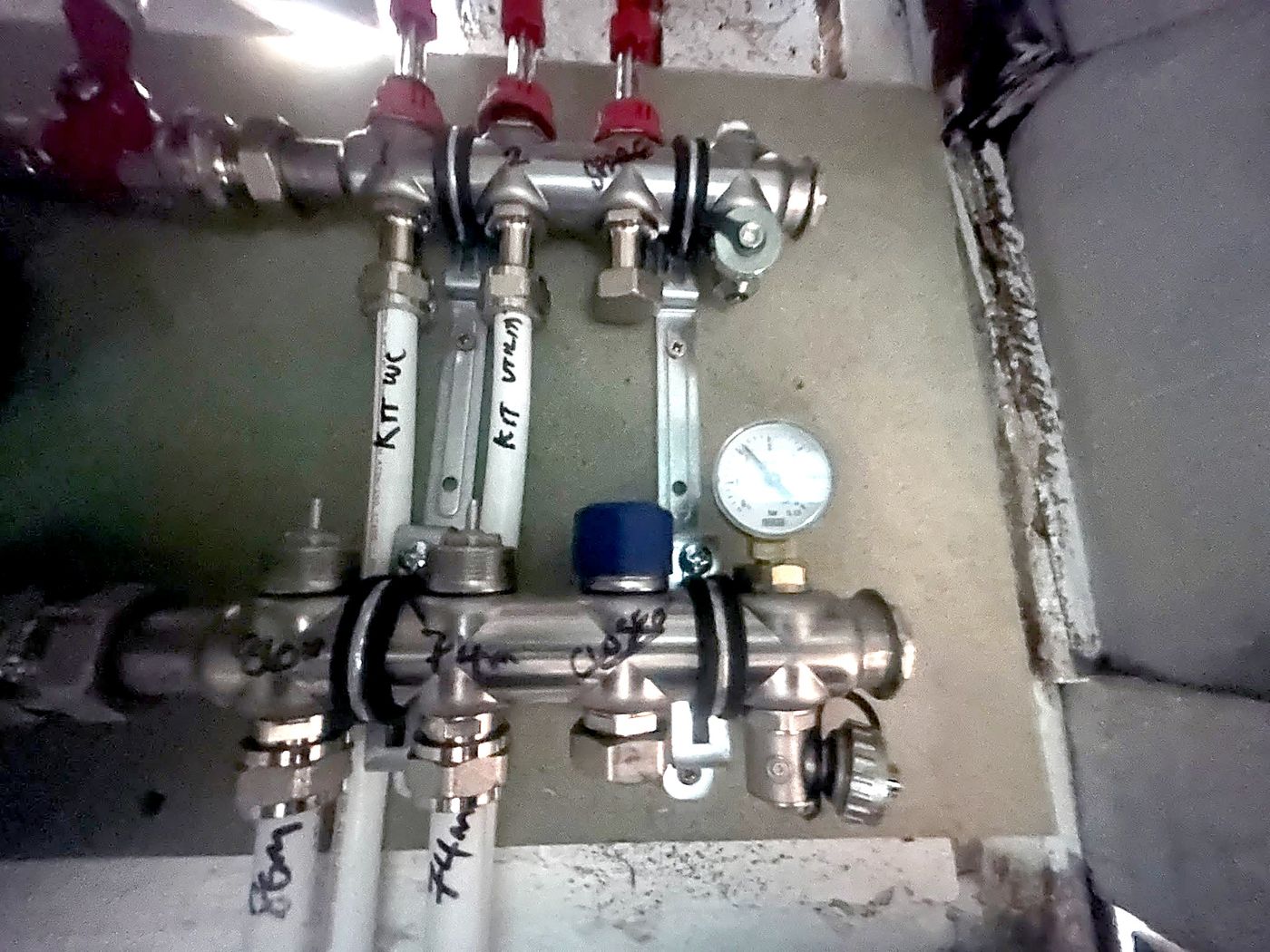 Underfloor heating manifold with flow meters, isolation valves and pressure gauge, circuits labelled with lengths