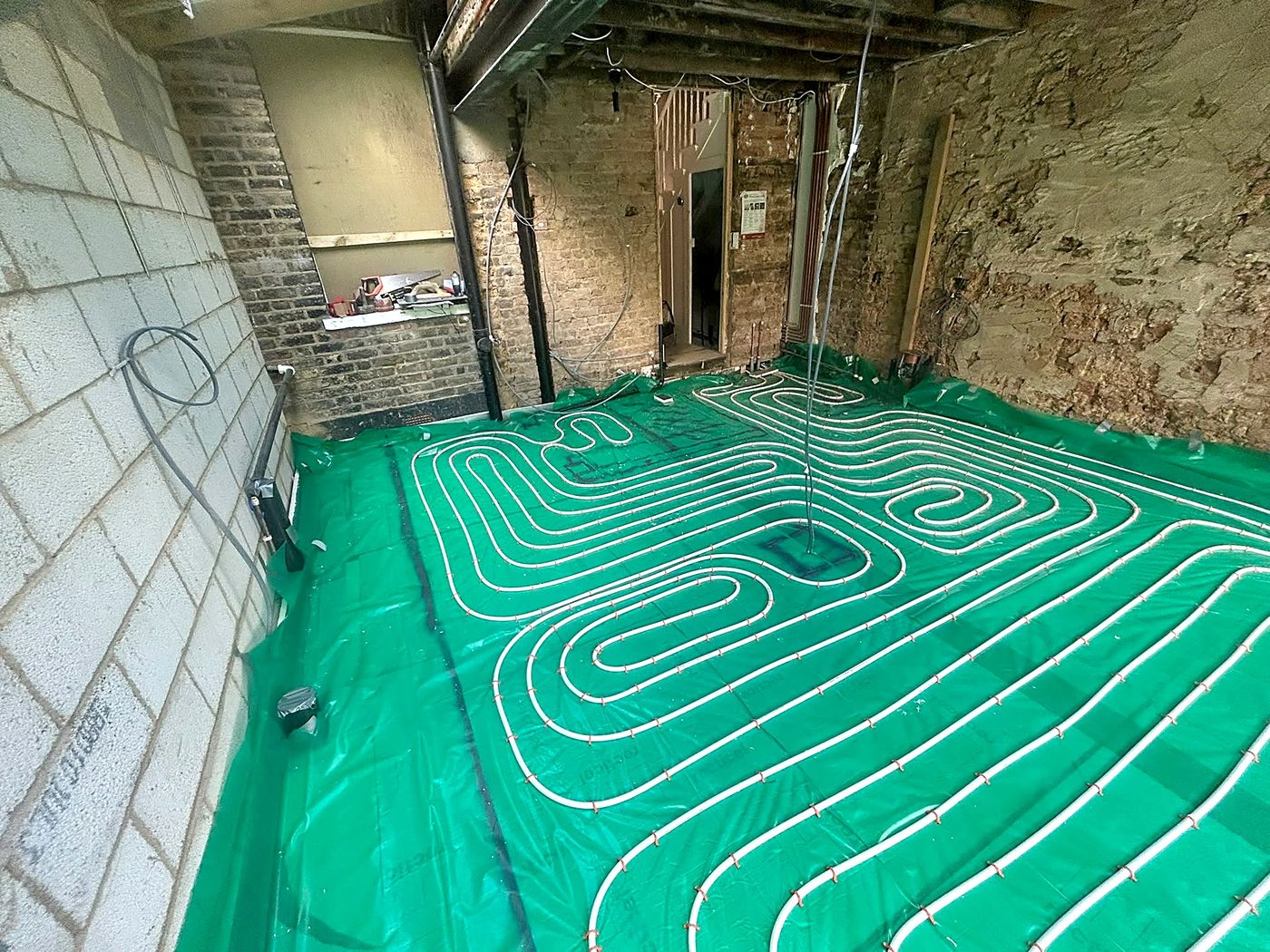 Underfloor heating pipe layout installed at 200mm centres over insulation and damp proof membrane, Forest Gate, East London
